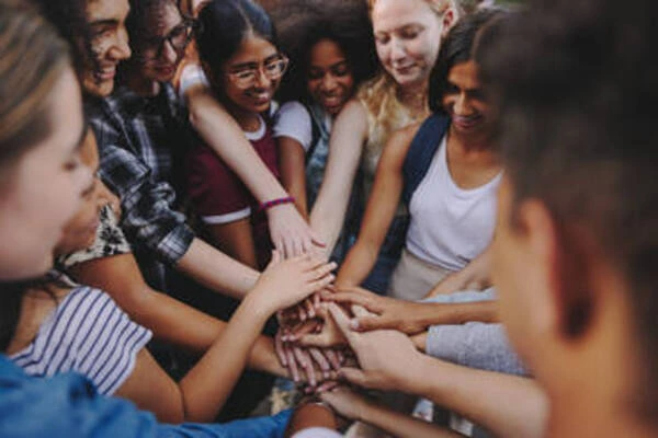 Niños trabajando juntos en equipo, colaborando y sonriendo mientras resuelven una actividad compartida.