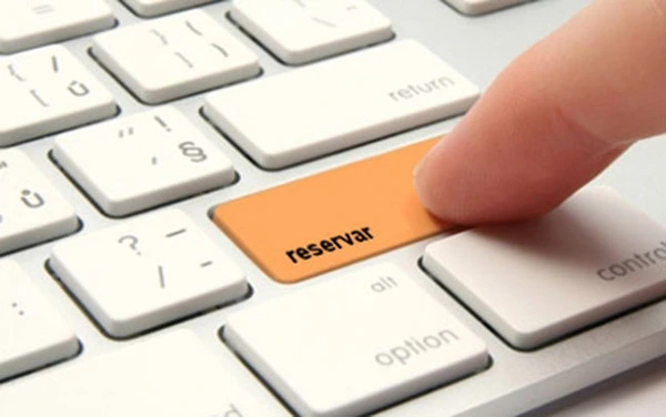 un dedo y teclado con un boton "reservar"