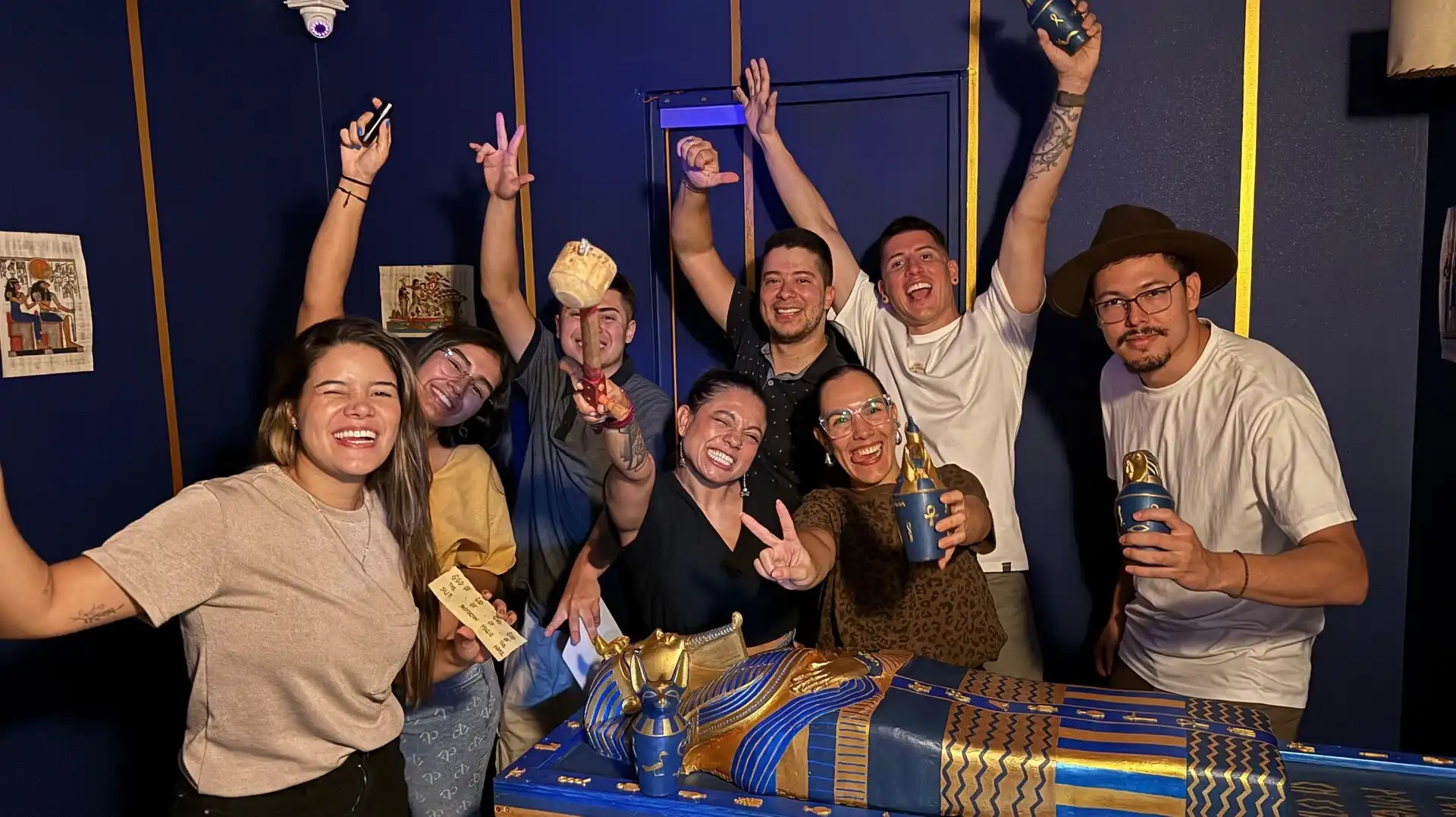 Grupo de amigos celebrando haber escapado de la sala egipcia La Tumba del Faraon en Rompecabezas Escape Room El Poblado Medellin