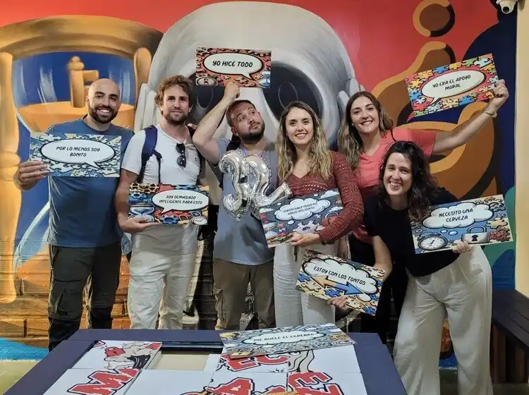 Backpackers gathered in front of art mural at Rompecabezas Escape Room El Poblado Medellín
