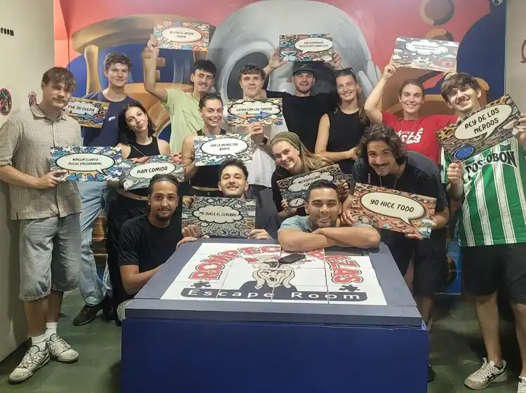 Large group of backpackers in front of graffiti mural at Rompecabezas Escape Room Medellín