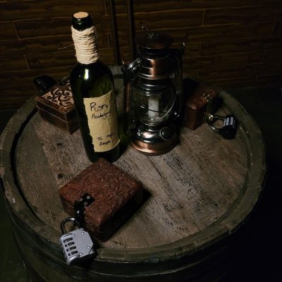 Juego de Escape – Piratas una botella de ron en un barco pirata con cajas con candados